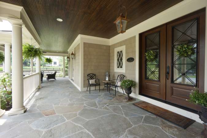 Sprawling Slate Stone Covered Front Porch With Gas Lights
