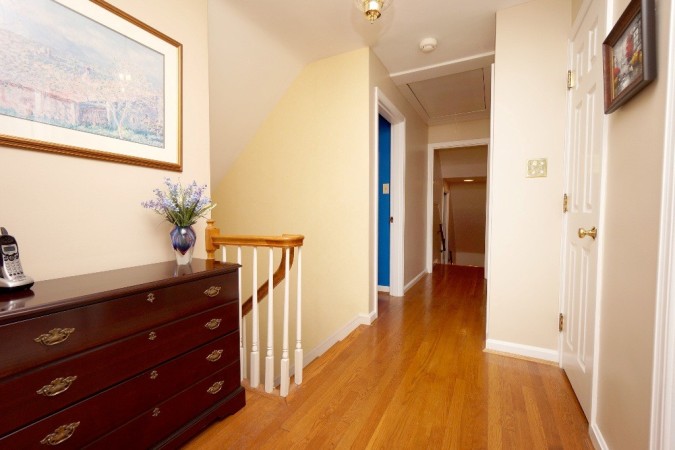 Hardwood flooring in the second floor hallway and dual staircase